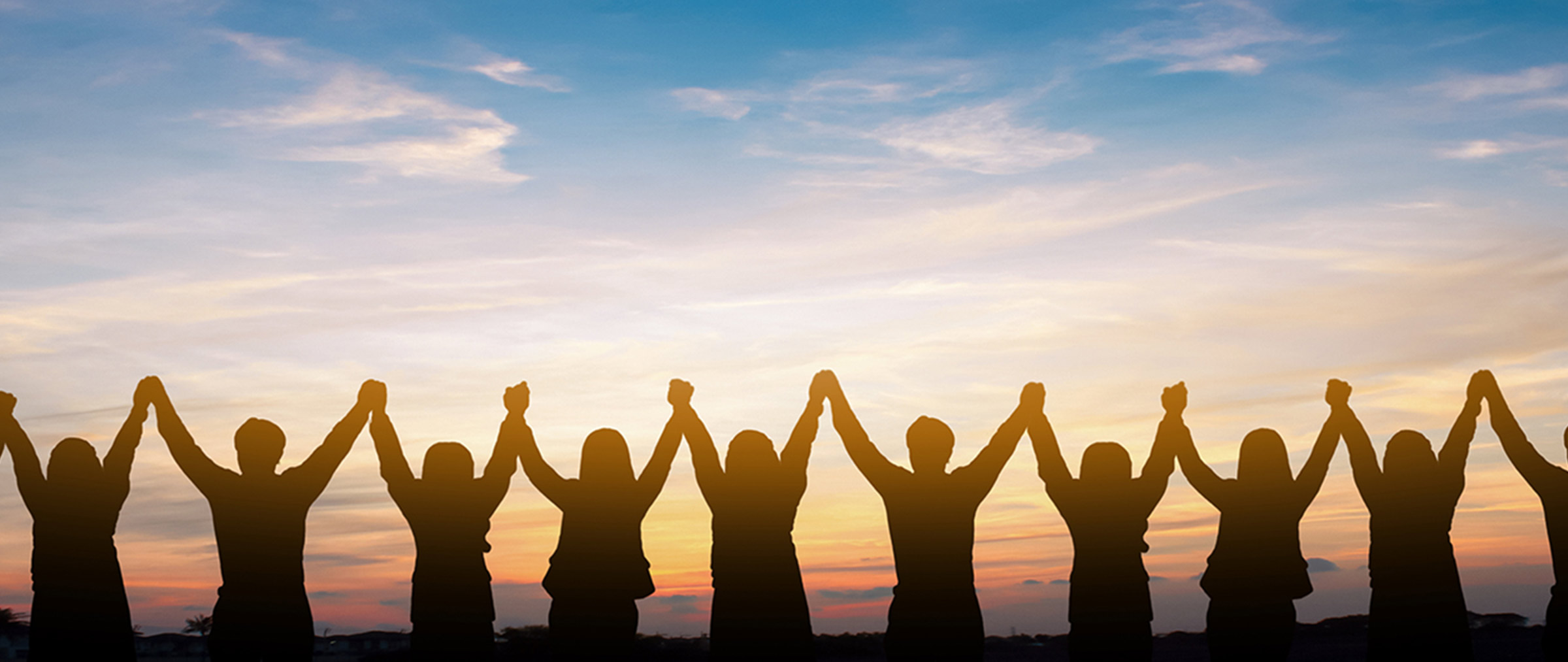 Photo silhouette of people holding hands in the air against a sunset