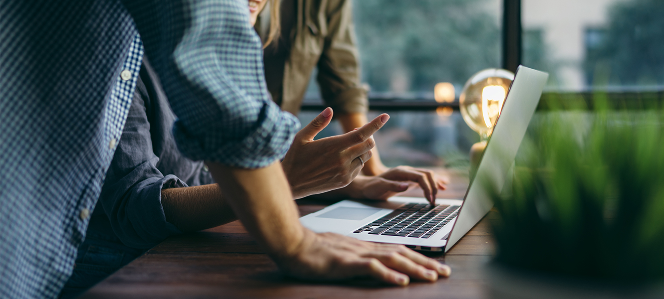 three people having a meeting, looking at a laptop