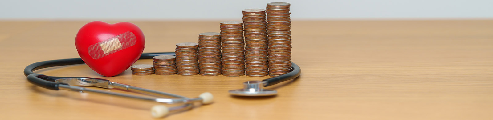 photo of stethoscope, heart, coins