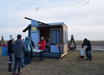 Photo of small replica of Wiggins branch with people standing in line for beverages.